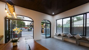 Un interior moderno con una mesa de madera, una planta en maceta y un banco con cojines.