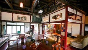 Una habitación tradicional japonesa con suelo de tatami, una mesa de madera baja y un sofá estilo tatami.