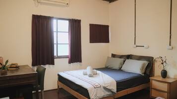 A bedroom with a wooden bed, a desk, and a chair.