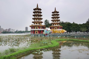 A pagoda-style building with multiple tiers, a dragon sculpture, and a water body with lily pads. - A Touch of Zen ─ A Restored Japanese Colonial Era Guest House (Kaohsiung)