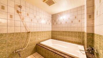 A bathroom with a bathtub, shower, and tiled walls.