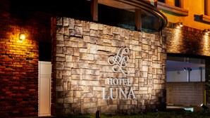 A stone wall with the sign "HOTEL LUNA" and a small trophy on the ground. - Hotel Luna Otsu (Otsu)