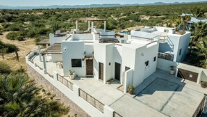 A modern house with a rooftop terrace, a covered patio, and a view of a desert landscape. - CASA TAKO 2, CLEAN modern studio unit, 5 minutes walk to kite launch beach. (La Ventana)