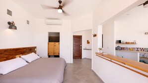 A bedroom with a bed, wooden headboard, and a ceiling fan. - CASA TAKO 2, CLEAN modern studio unit, 5 minutes walk to kite launch beach. (La Ventana)