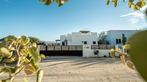 A modern building with a flat roof, a small garden area, and a clear blue sky. - CASA TAKO 2, CLEAN modern studio unit, 5 minutes walk to kite launch beach. (La Ventana)