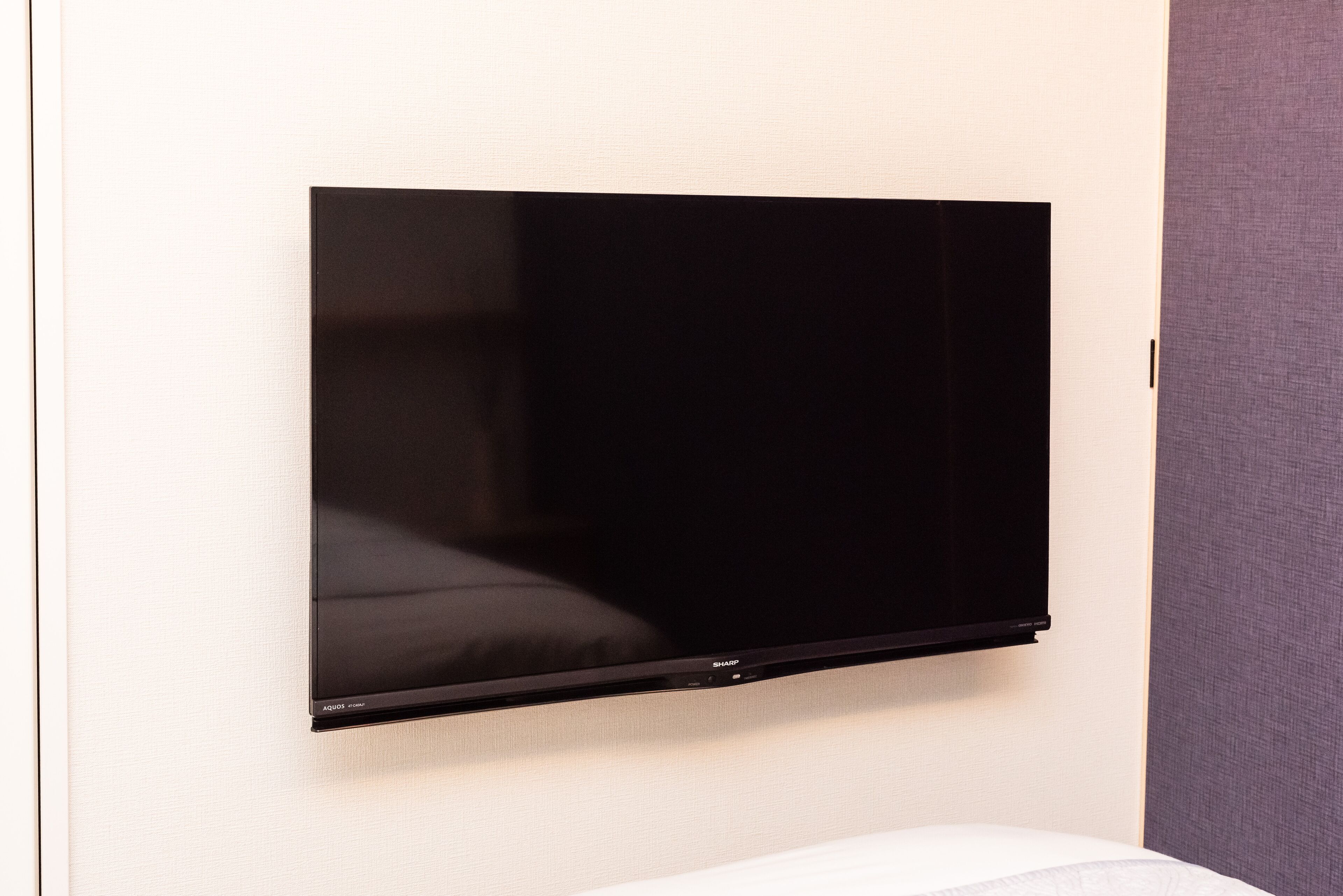 A flat-screen TV mounted on a wall in a hotel room.