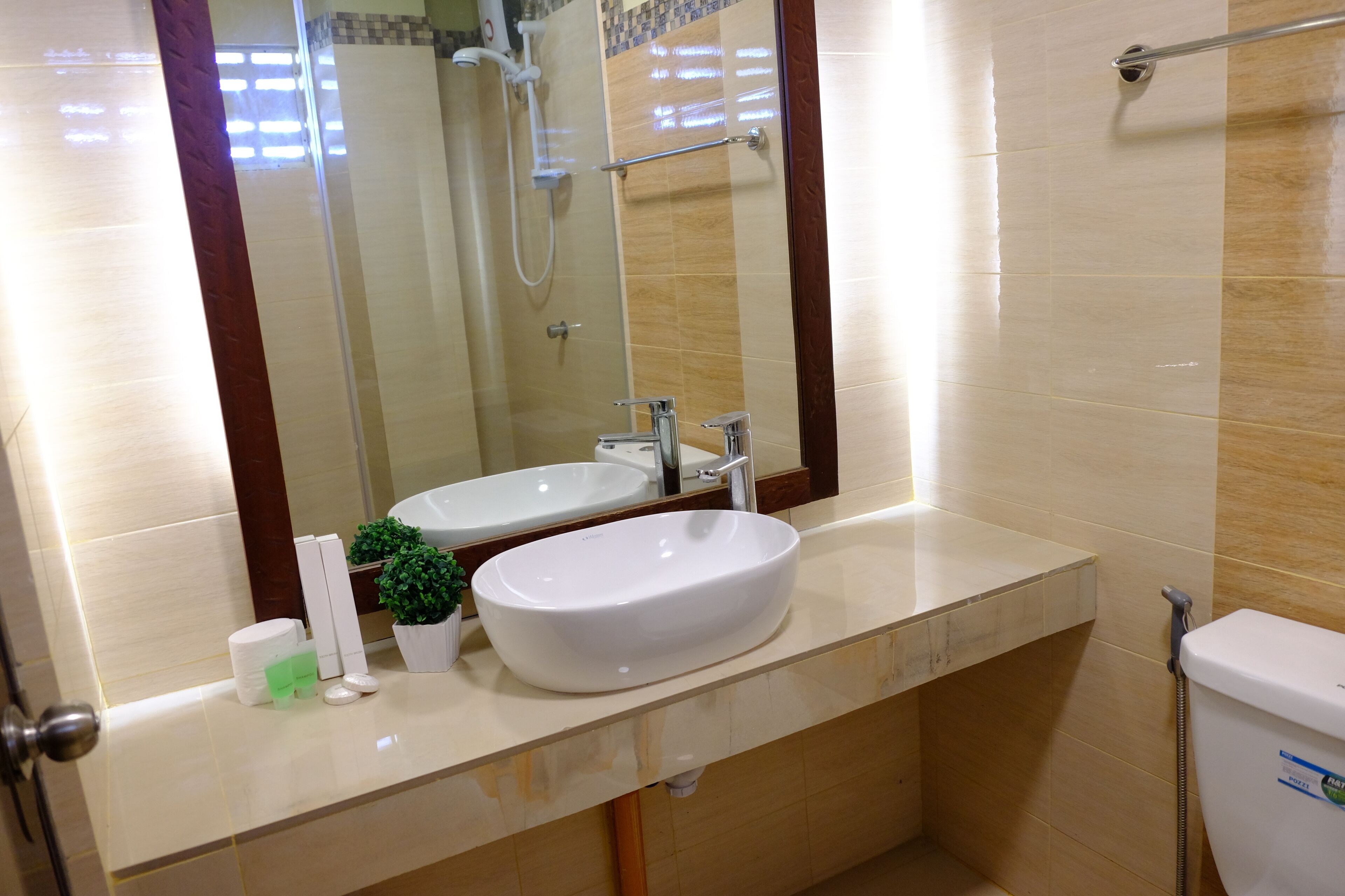 A bathroom with two sinks, a shower, and a toilet.