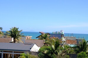 Un barrio costero con edificios, palmeras y vista al mar.