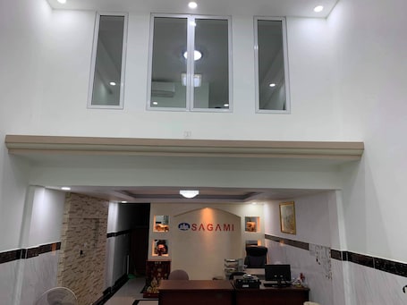 A reception area with a reception desk, a chandelier, and a wall-mounted air conditioning unit.