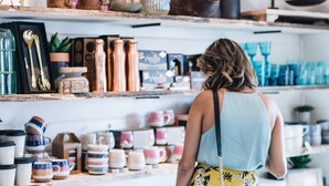 Una persona observa estantes con diverso menaje de cocina y objetos decorativos.