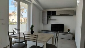 Een moderne keuken met een flatscreen televisie, inbouwmeubels en een eethoek met een tafel en stoelen.