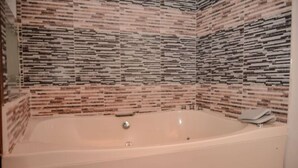 A bathroom with a freestanding bathtub, tiled walls, and a shower area. - Hot tub 1 bedroom AC Security 2 blocks from lleras (Medellin)