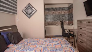 A bedroom with a bed, a desk, and a chair. - Hot tub 1 bedroom AC Security 2 blocks from lleras (Medellin)