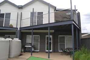 A two-story house with a balcony, a barbecue grill, and a patio area. - Waterview - 2 Doc Crt (Yarrawonga)