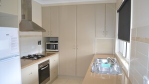 Una cocina con estufa, microondas, horno y lavaplatos.