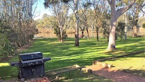 A park with a barbecue grill, picnic tables, and a brick pathway. - Water's Edge Bundalong (Bundalong)