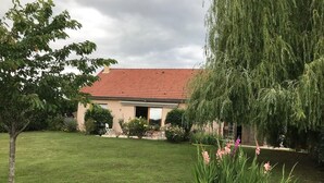A house with a red-tiled roof, surrounded by a well-maintained lawn and various plants. - Detached house on large plot of land near Jura and wine route (Vielverge)