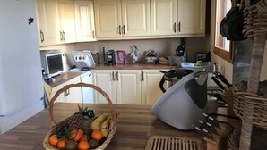 A kitchen with white cabinets, a microwave, a coffee maker, and a fruit basket on the counter. - Detached house on large plot of land near Jura and wine route (Vielverge)