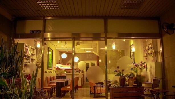 En restaurant med glasefterdør, træloft og indendørs siddepladser.