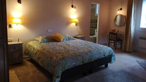 Un dormitorio con cama, lámparas de noche, mesita de noche, cómoda, espejo y una silla.