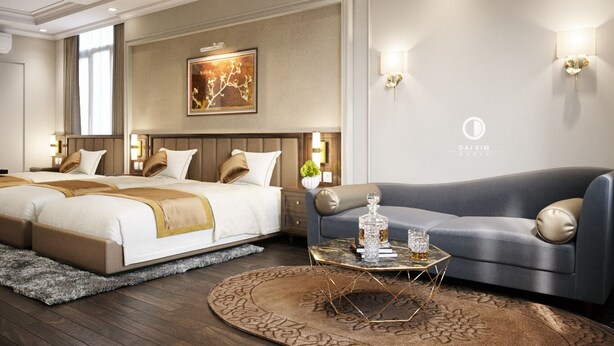 Quarto de hotel com uma cama grande, um sofá e uma mesa de centro. Há um quadro na parede e duas arandelas.