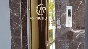 Um elevador moderno com superfície espelhada e um logotipo no centro.