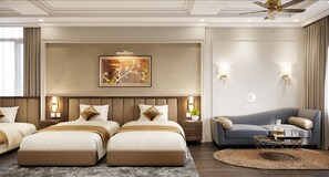 A hotel room with two beds, a sofa, a round coffee table, and a ceiling fan. - An Phu Ha Long Luxury Hotel (Bai Chay)
