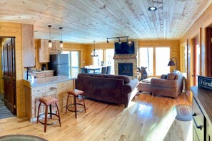 Un intérieur de cabine spacieux comprenant une cuisine, un coin salon et une cheminée.