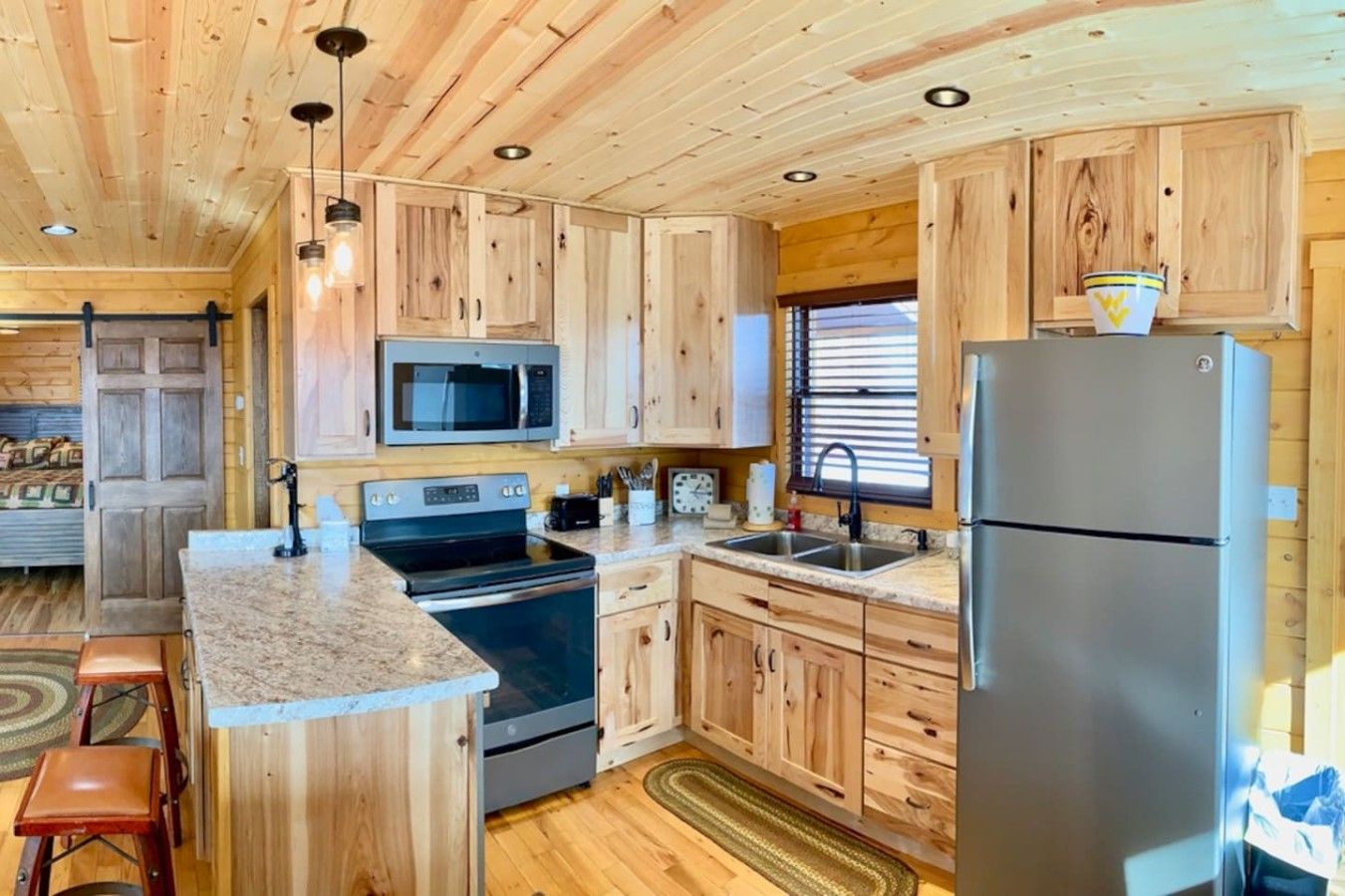 A kitchen with wooden cabinets, a stainless steel refrigerator, and a microwave.