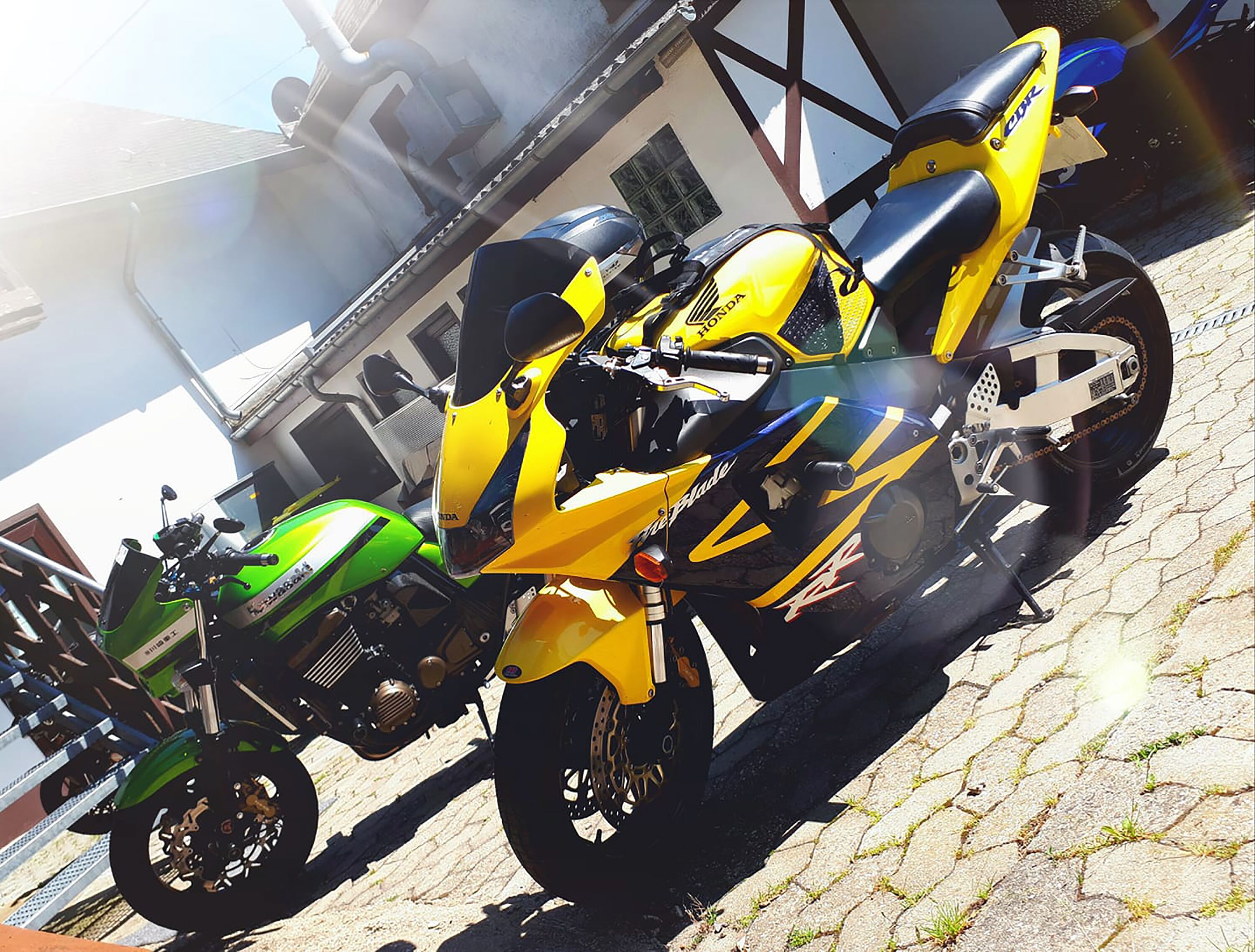 Dos motocicletas estacionadas sobre adoquines.