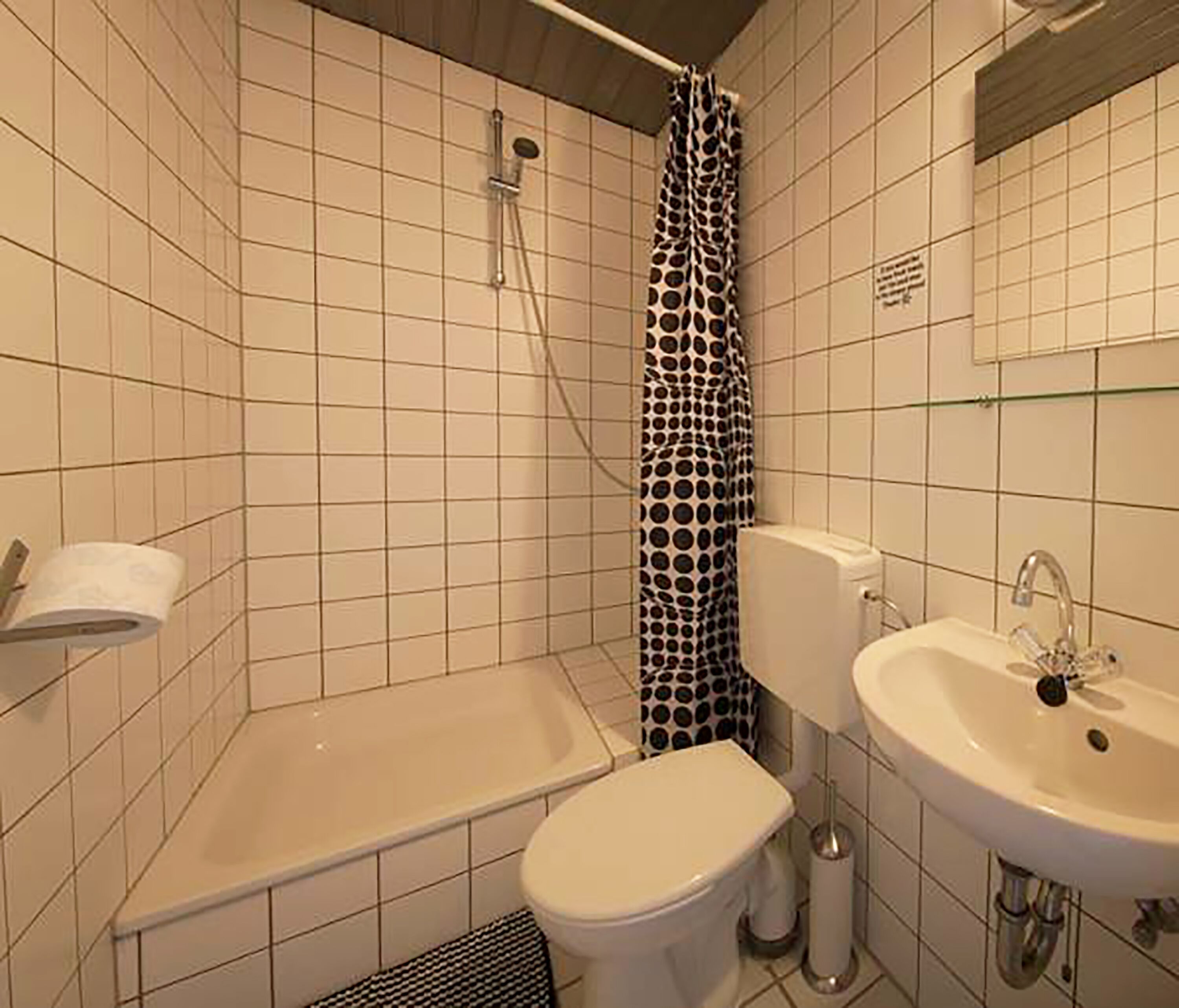 Un bagno con vasca, water e lavandino.