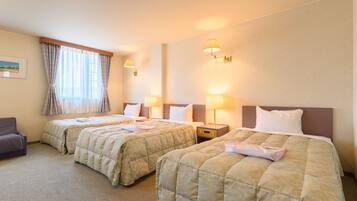 A hotel room with two beds, a chair, and a nightstand with lamps.