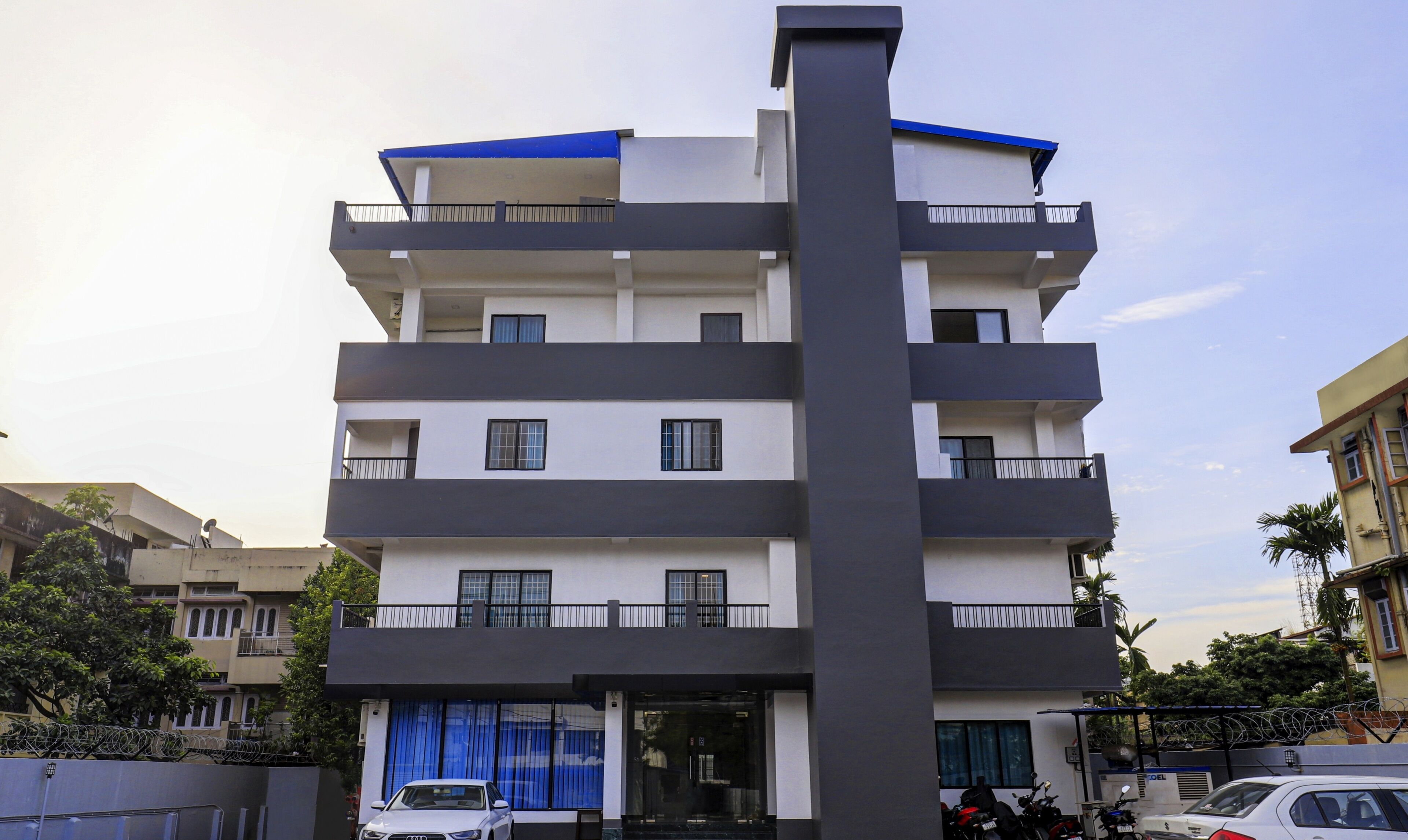 A multi-story building with balconies, a garage, and a security gate.