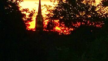 Una iglesia con una aguja puntiaguda silueteada contra el ocaso.