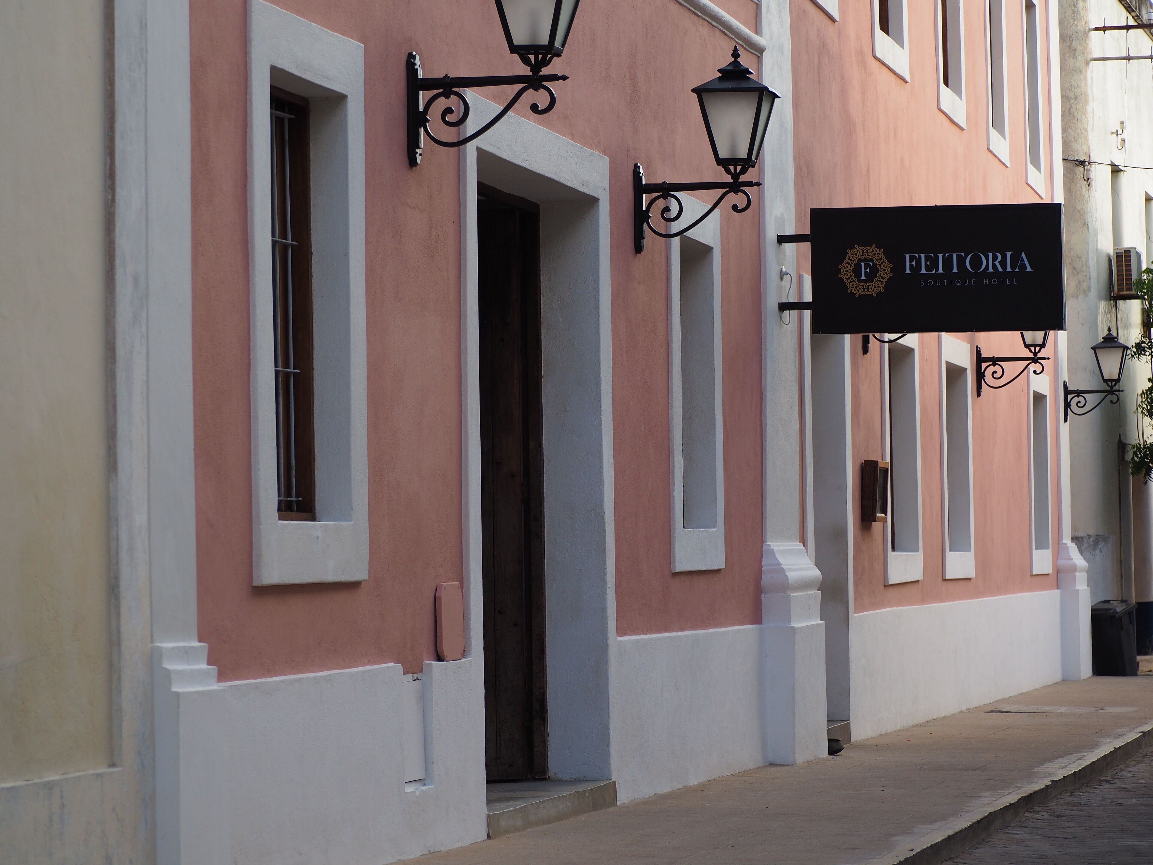 Un edificio con un cartel que dice 'FEITORIA Boutique Hotel'.