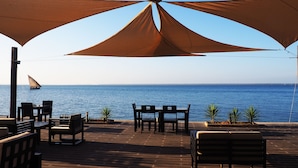 Un espacio al aire libre con vistas al mar, que incluye un velero a lo lejos.