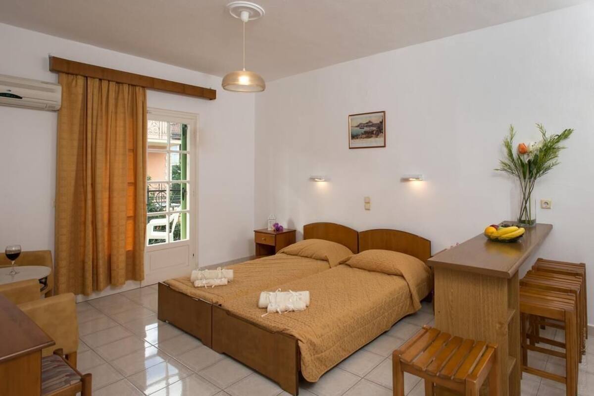 A hotel room with a bed, bedside tables, a desk, and a window with curtains.