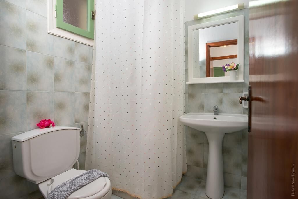 A bathroom with a toilet, a sink, and a shower curtain.