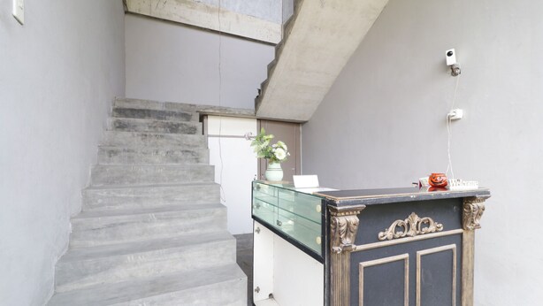 A staircase leading to a landing with a glass-fronted cabinet and a welcome sign.
