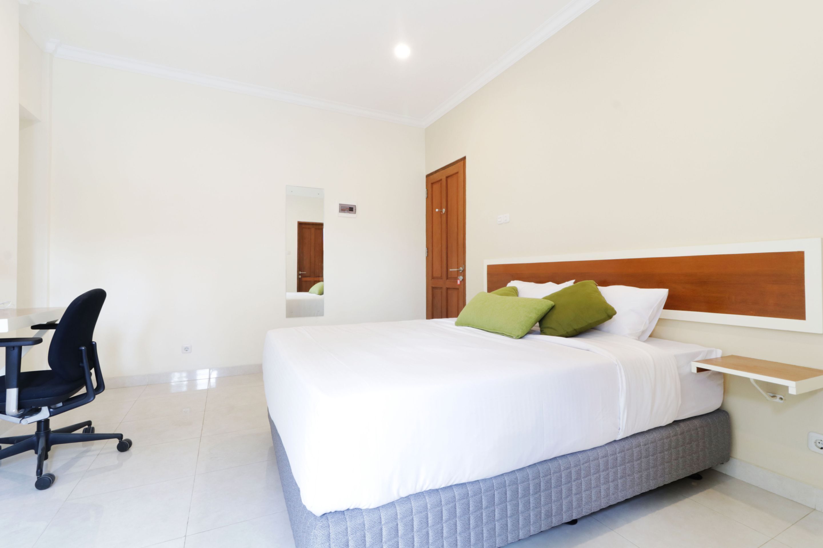 A hotel room with a bed, a desk, and a chair.