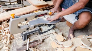 A woodworking scene with a person using a table saw. - Griya Erlangga Homestay (Bantul)