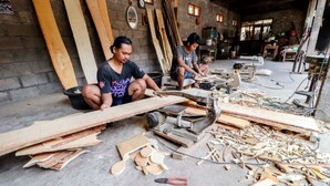 Two individuals working with woodworking tools and materials in a workshop setting. - Griya Erlangga Homestay (Bantul)