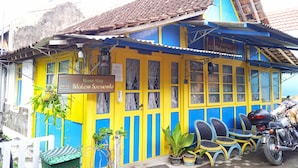 Un edificio colorido con un letrero que dice 'Home Stay Adelém Soewondo'.