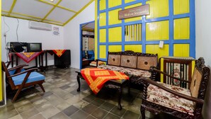Una habitación con piso a cuadros, un sofá, un sillón, un televisor y un letrero que dice "Home Stayondo Idealem Sozonde".