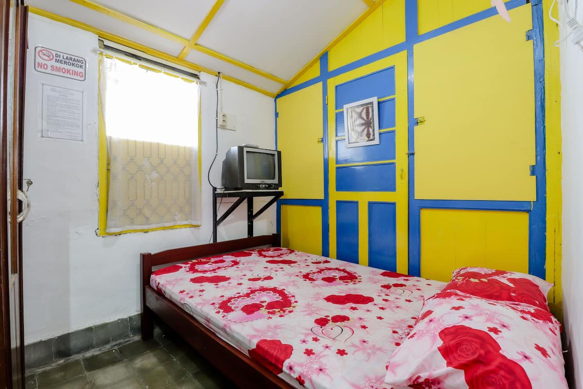 A bedroom with a bed, a television, and a 'No Smoking' sign.