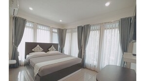 Une chambre à coucher moderne avec un grand lit, une table de chevet et une chaise.