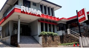 Un bâtiment moderne avec une enseigne bien visible indiquant « RUMA HOSTEL ».
