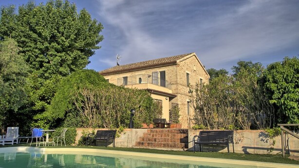 A pool area with a stone building, outdoor furniture, and lush greenery. - Large historic villa with pool, panoramic views surrounded by greenery (Ostra)