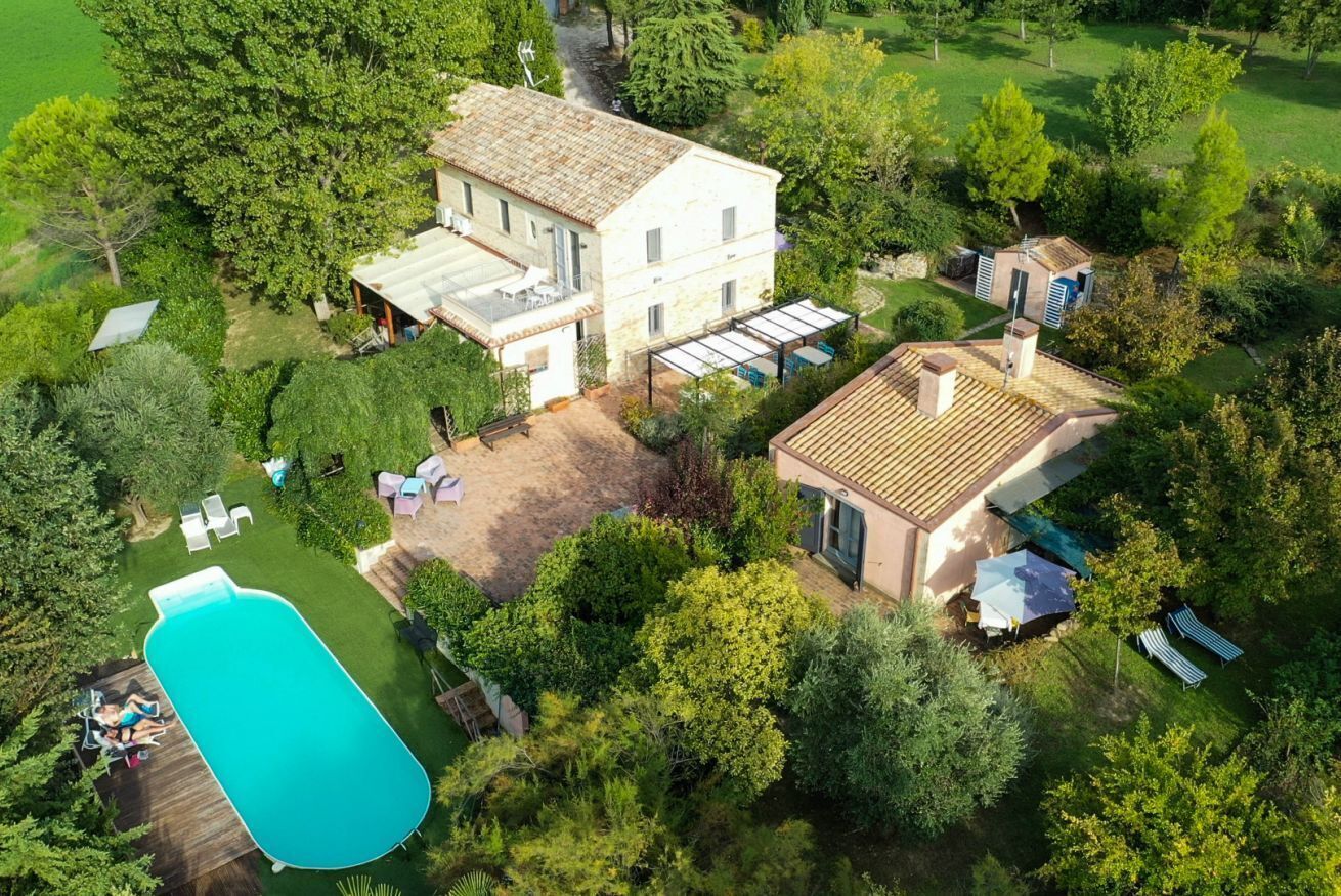 Ein großes Haus mit Swimmingpool, Terrasse und Garten.