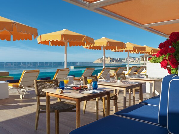 A terrace with tables and chairs, overlooking a body of water. - H10 Porto Poniente (Benidorm)